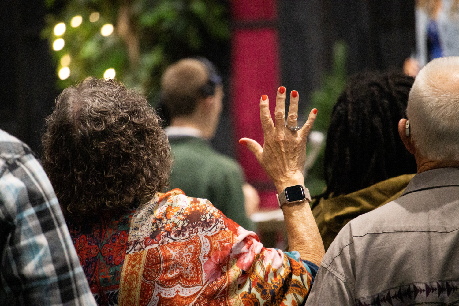 a woman raising her hand in worship